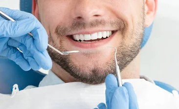 Man smiling with white teeth at the dentist